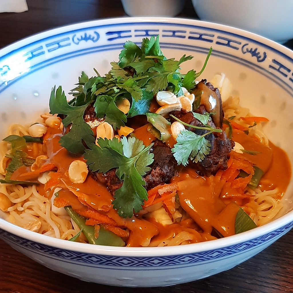 Bowl of noodles topped with crispy baked tofu